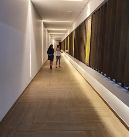 Pasillo interior moderno en Torres de Barlovento, con iluminación arquitectónica y áreas comunes elegantes